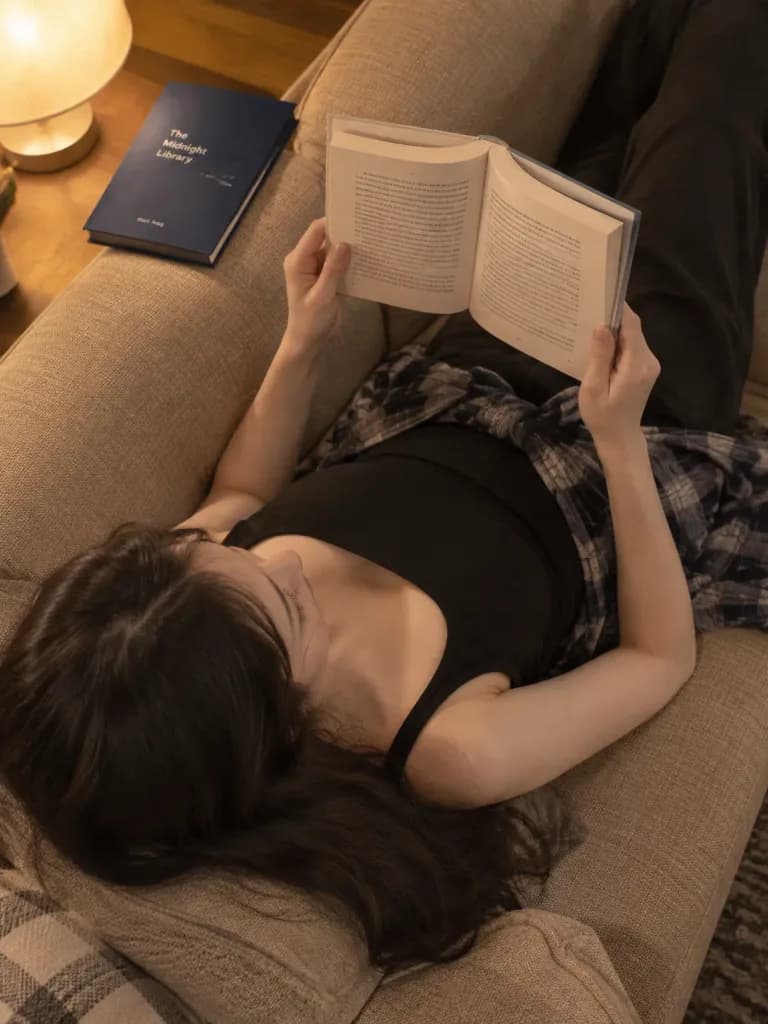 소파에서 독서하는 아늑한 여성