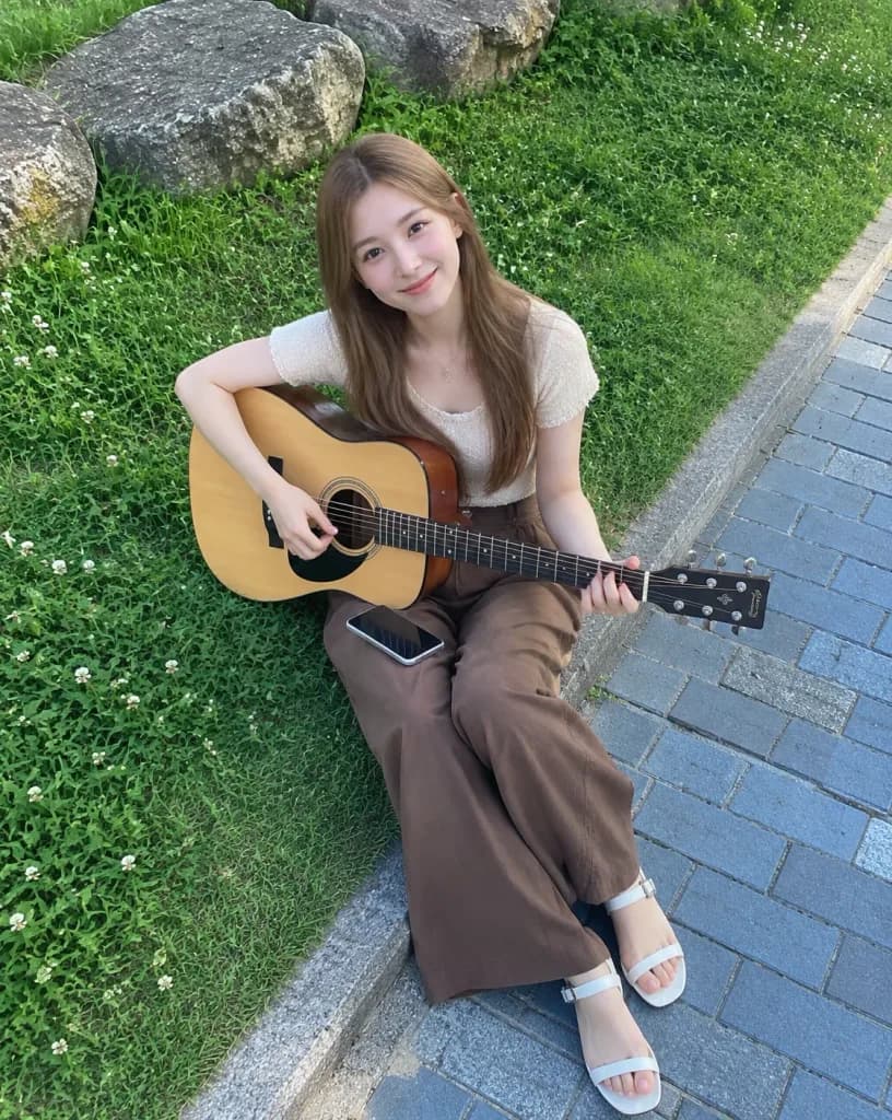 公園でアコースティックギターを持つ女性